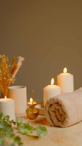 Vertical-Video-Still-Life-Of-Lit-Candles-With-Dried-Grasses-Incense-Stick-And-Soft-Towels-As-Part-Of-Relaxing-Spa-Day-Decor